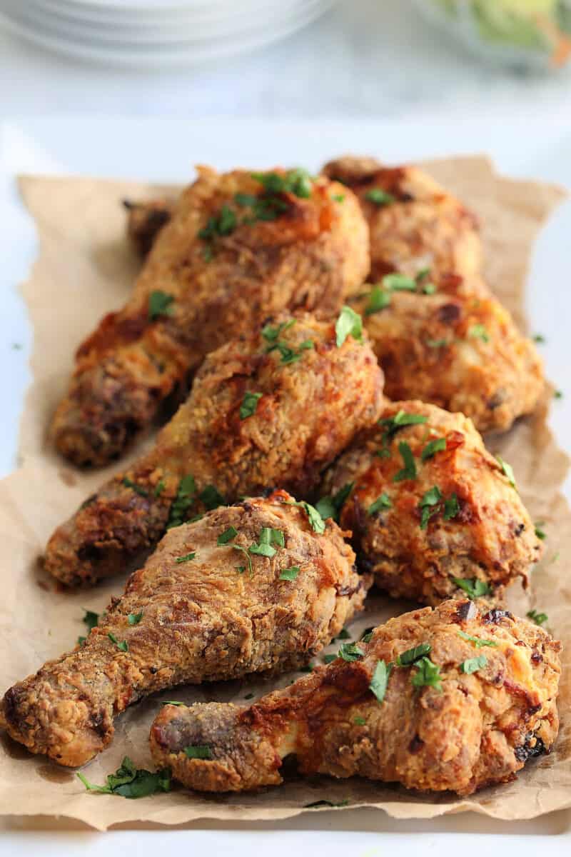 fried chicken drumsticks on brown paper on a table