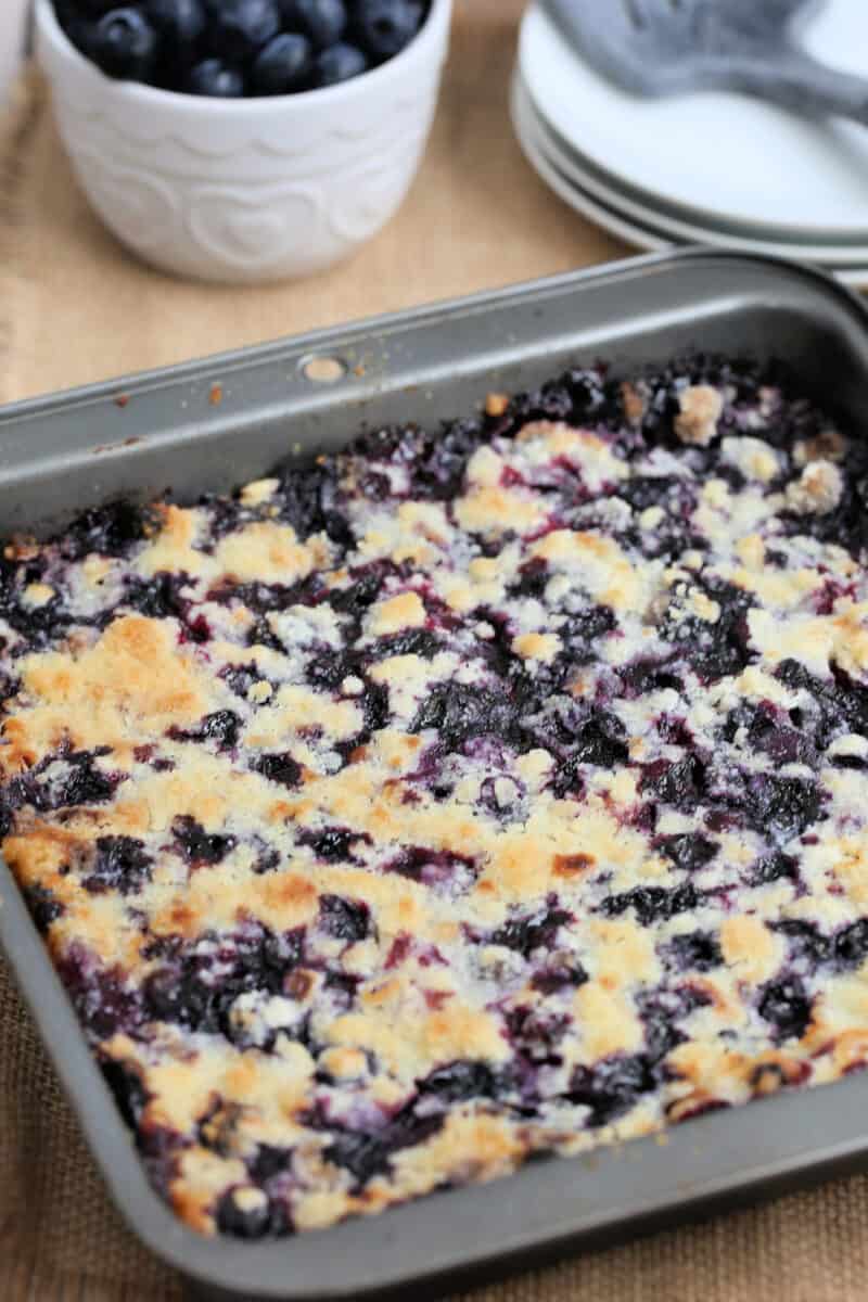 a square metal baking pan filled with uncut blueberry pie bars