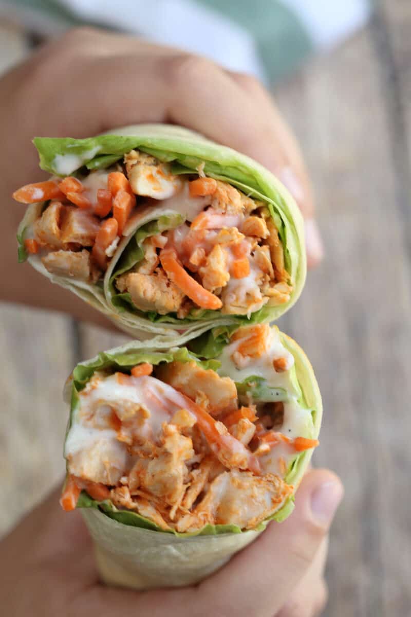 two buffalo chicken wraps being held with hands
