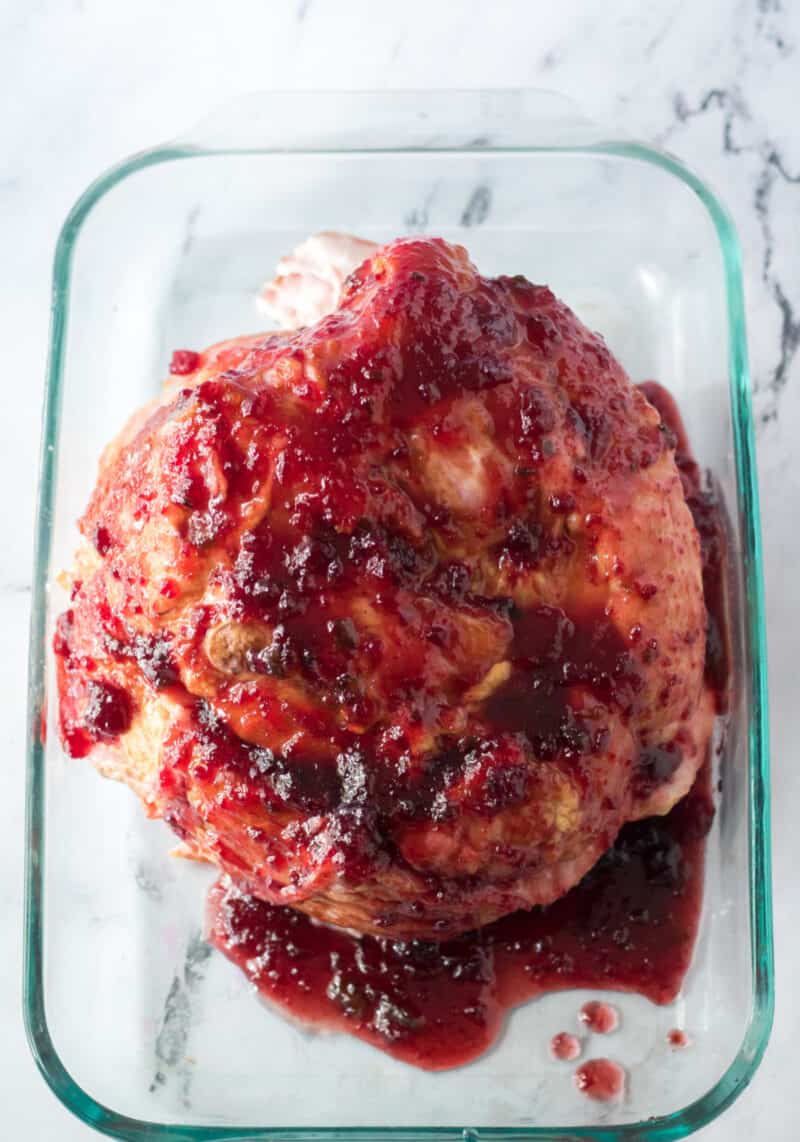 whole ham with cranberry glaze in baking dish on table