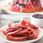 slices of ham on white plate on a holiday table