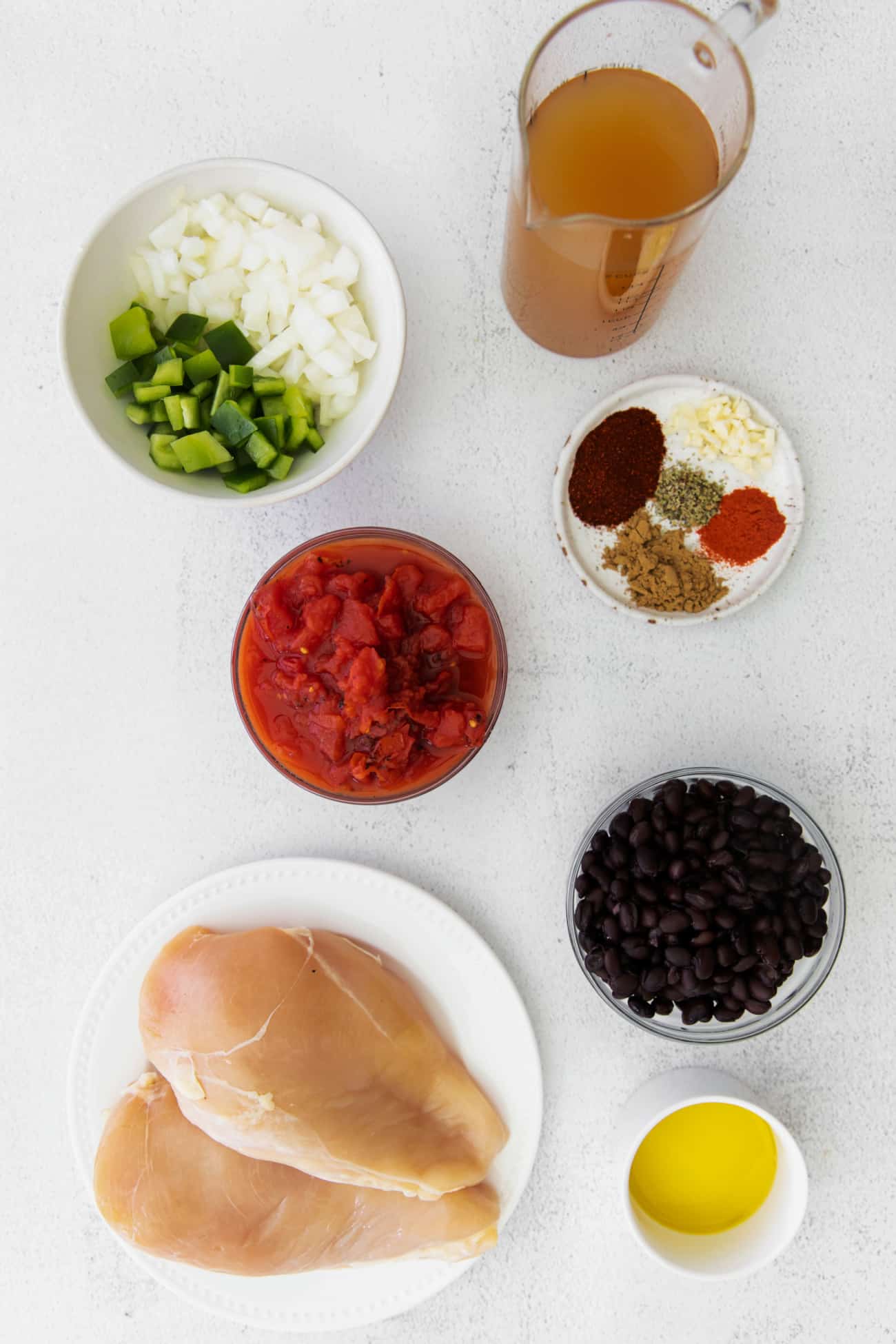 ingredients to make chicken tortilla soup in bowls on a table