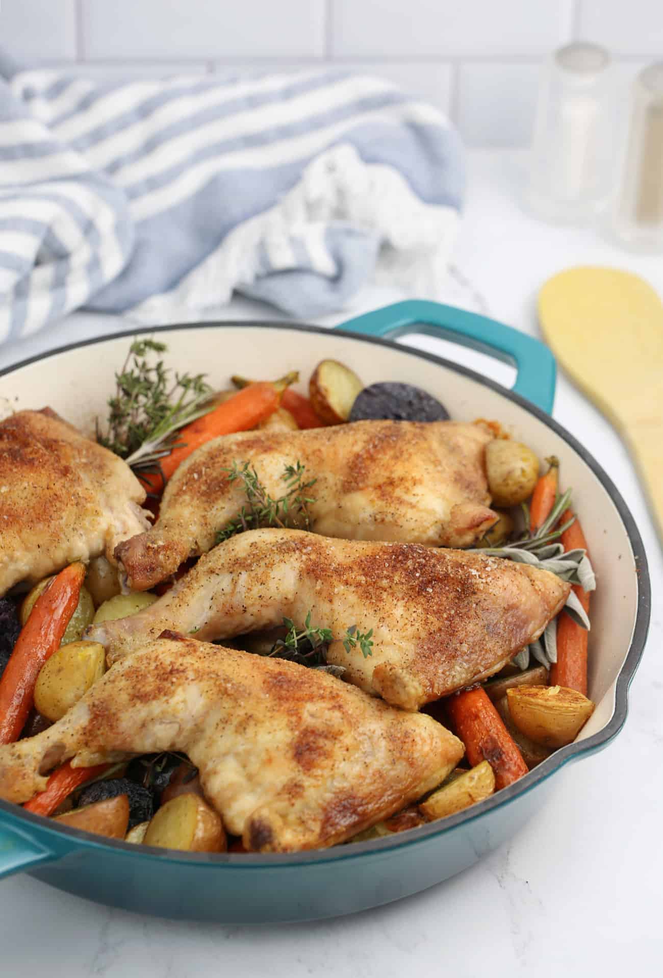 chicken leg quarters and vegetables in a skillet