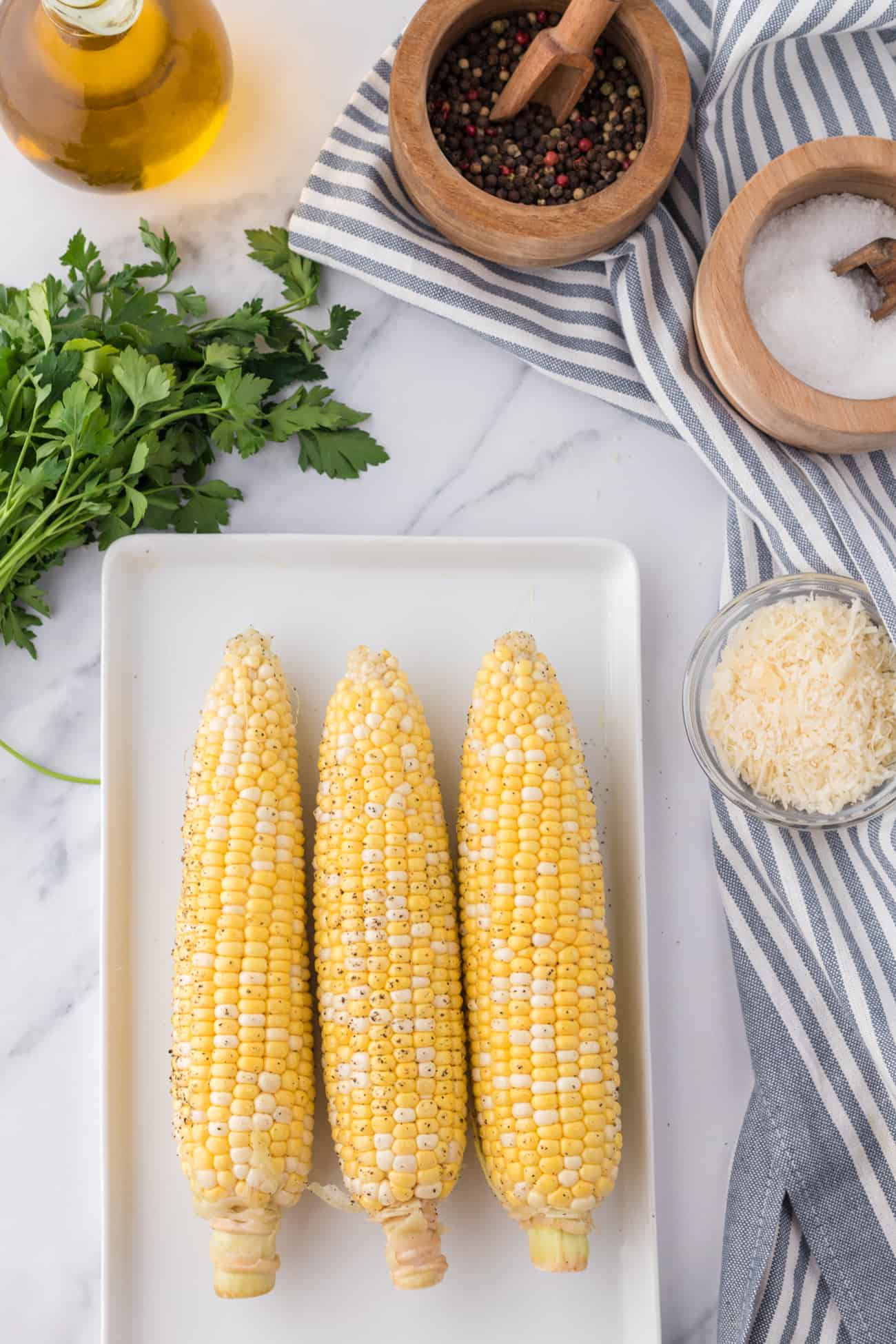 corn on the cob with topping ingredients around it