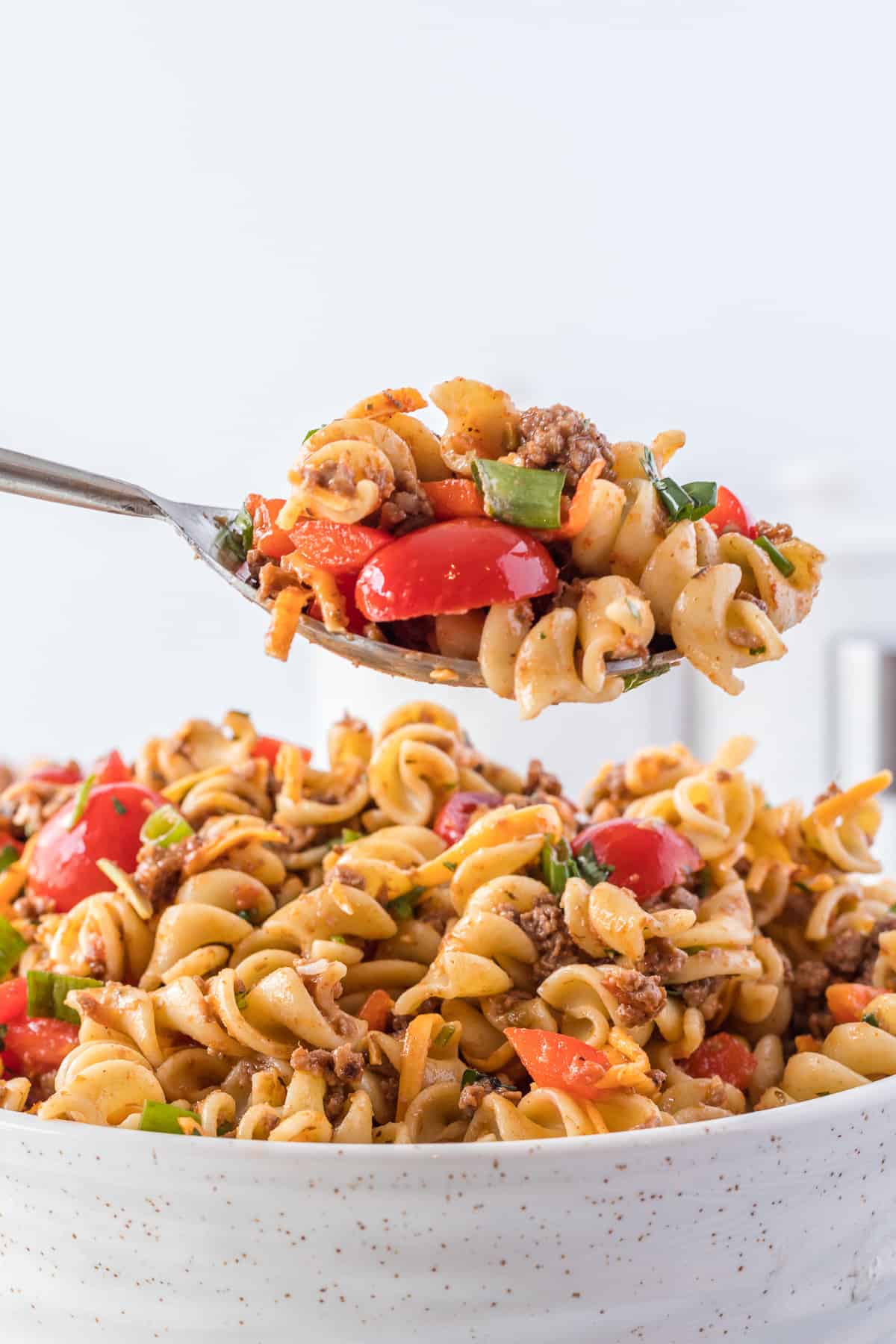 taco pasta salad on a spoon over a bowl full