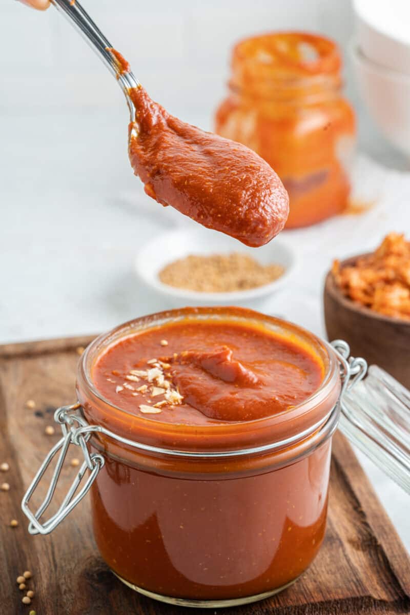 homemade bbq sauce on a spoon from a jar