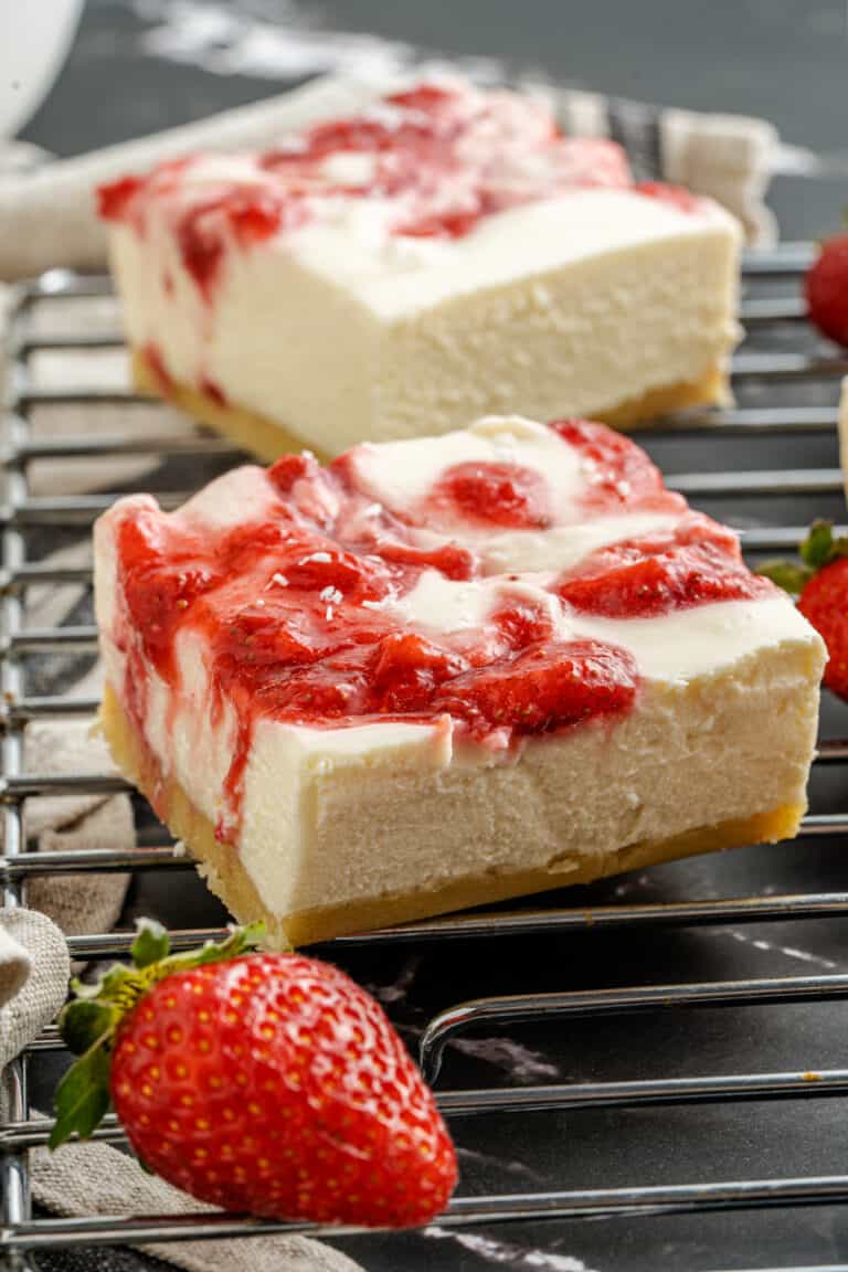 A piece of cake on a plate, with Cheesecake and Strawberry