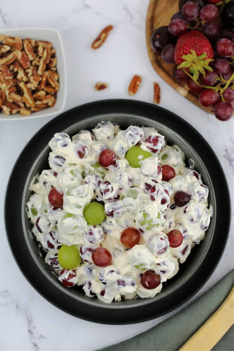 food in a bowl with pecans, with grape salad