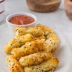 food on a plate, with mozzarella sticks and marinara sauce