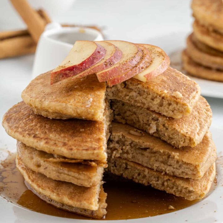 a stack of pancakes on a plate with maple syrup and apple sliced, with Oat Flour Pancakes