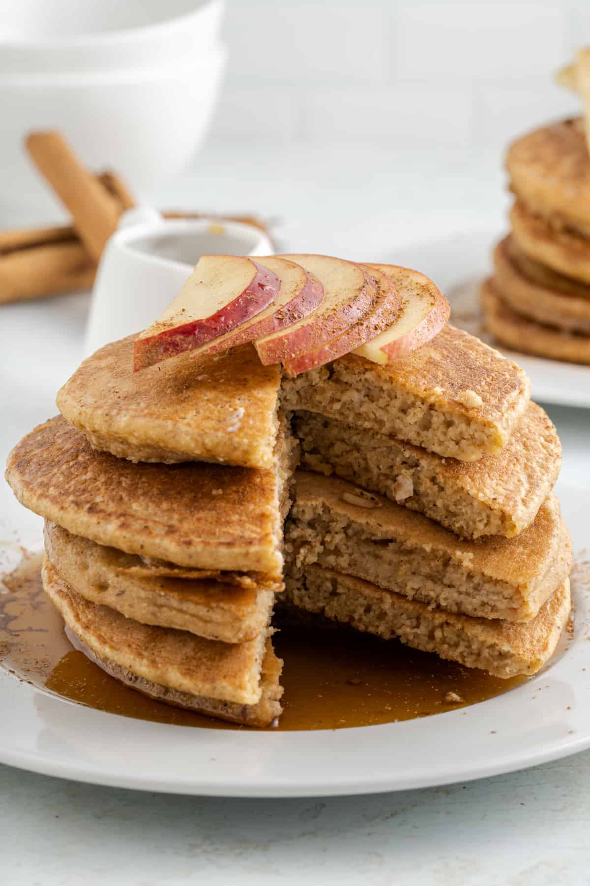 a stack of pancakes on a plate with maple syrup and apple sliced, with Oat Flour Pancakes