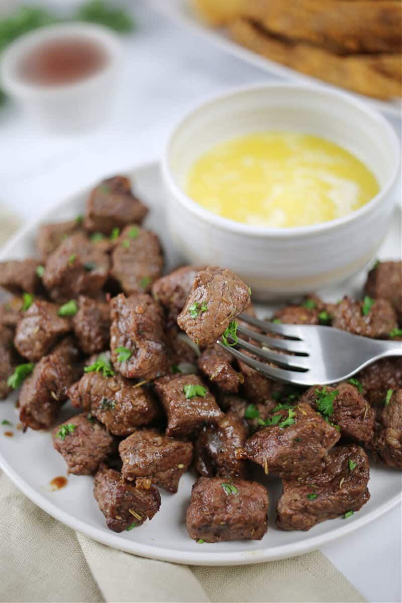 food on a fork over a plate, with Air Fryer Steak Bites