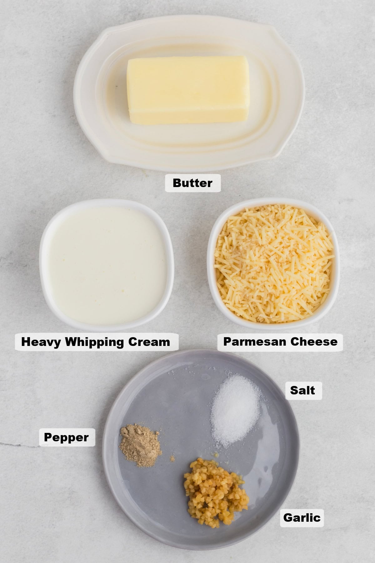 ingredients on a table such as butter, heavy cream, parmesan cheese, and seasonings.