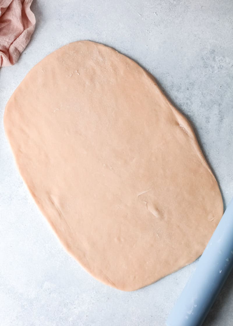 dough rolled onto a table into a rectangular shape.