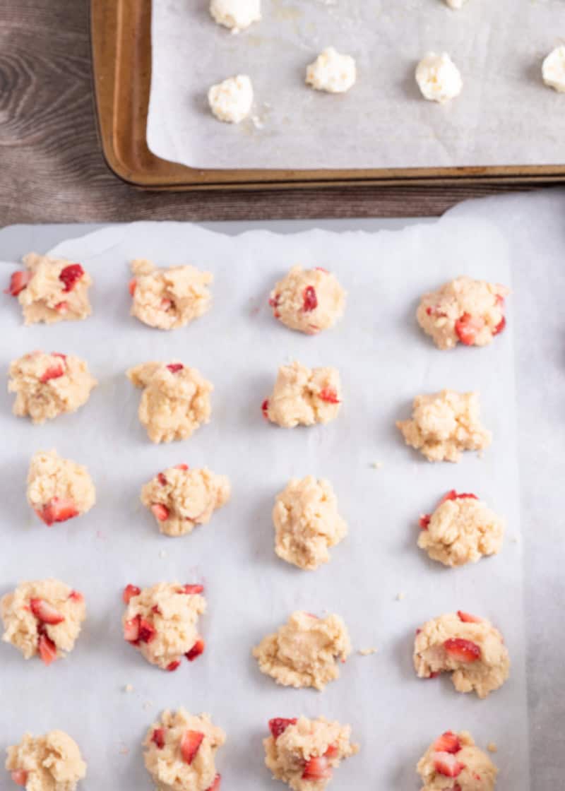 balls of uncooked cookie dough on parchment paper.