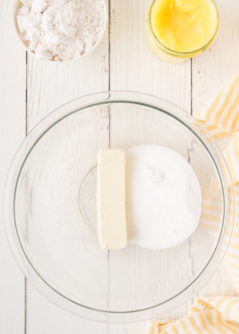 a glass bowl with unmixed granulated sugar and a stick of butter.