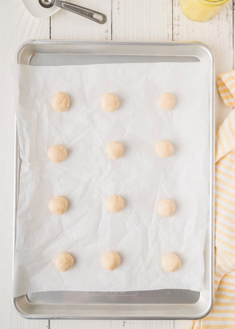 cookie balls on a parchment lined baking pan.