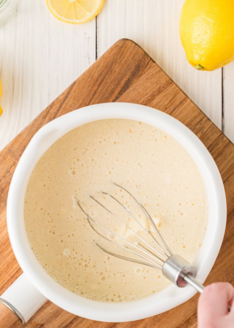 a whisk mixing mixture in a pan.