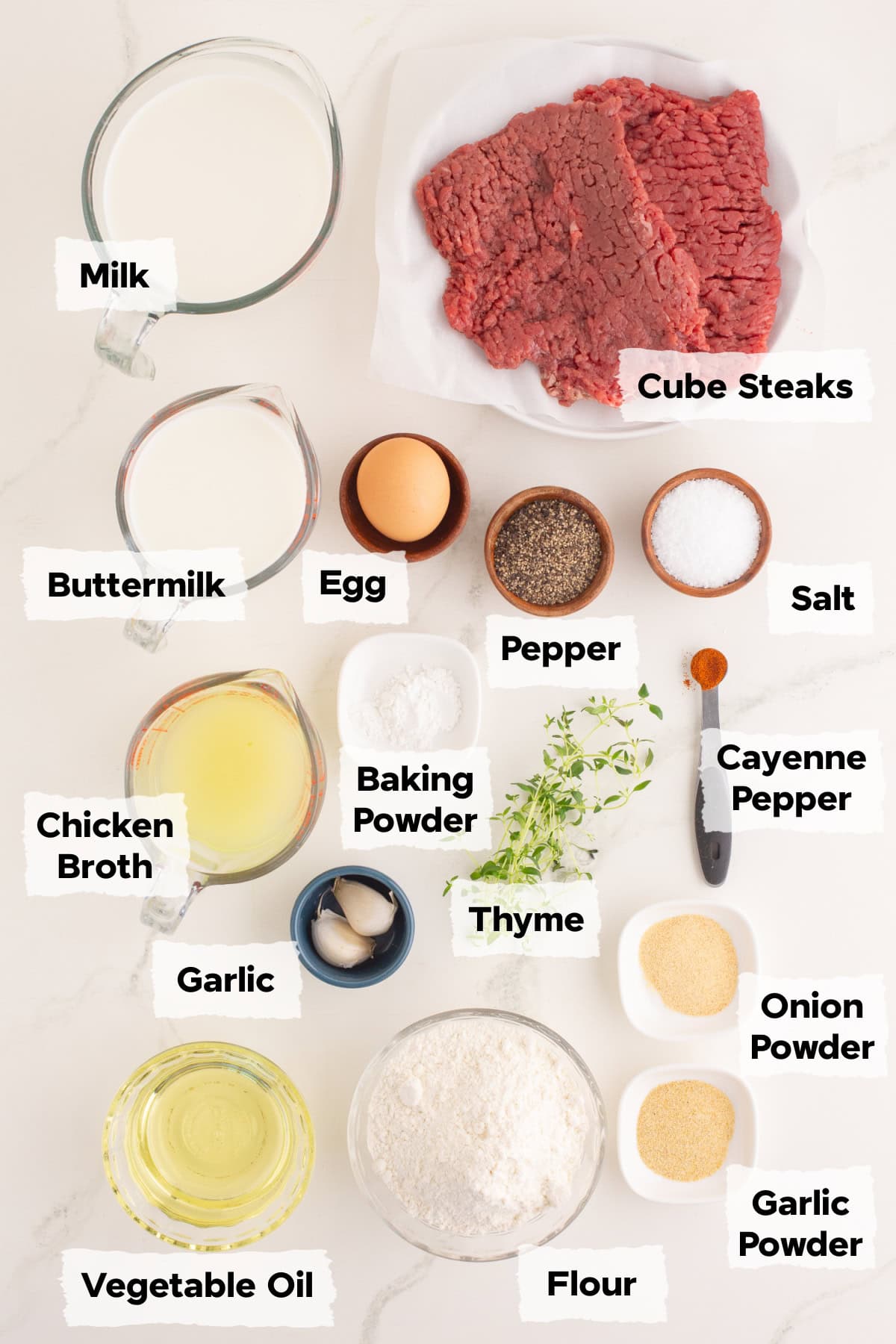 ingredients to make chicken fried steak including steak, flour, spices, milk, buttermilk, egg and oil.