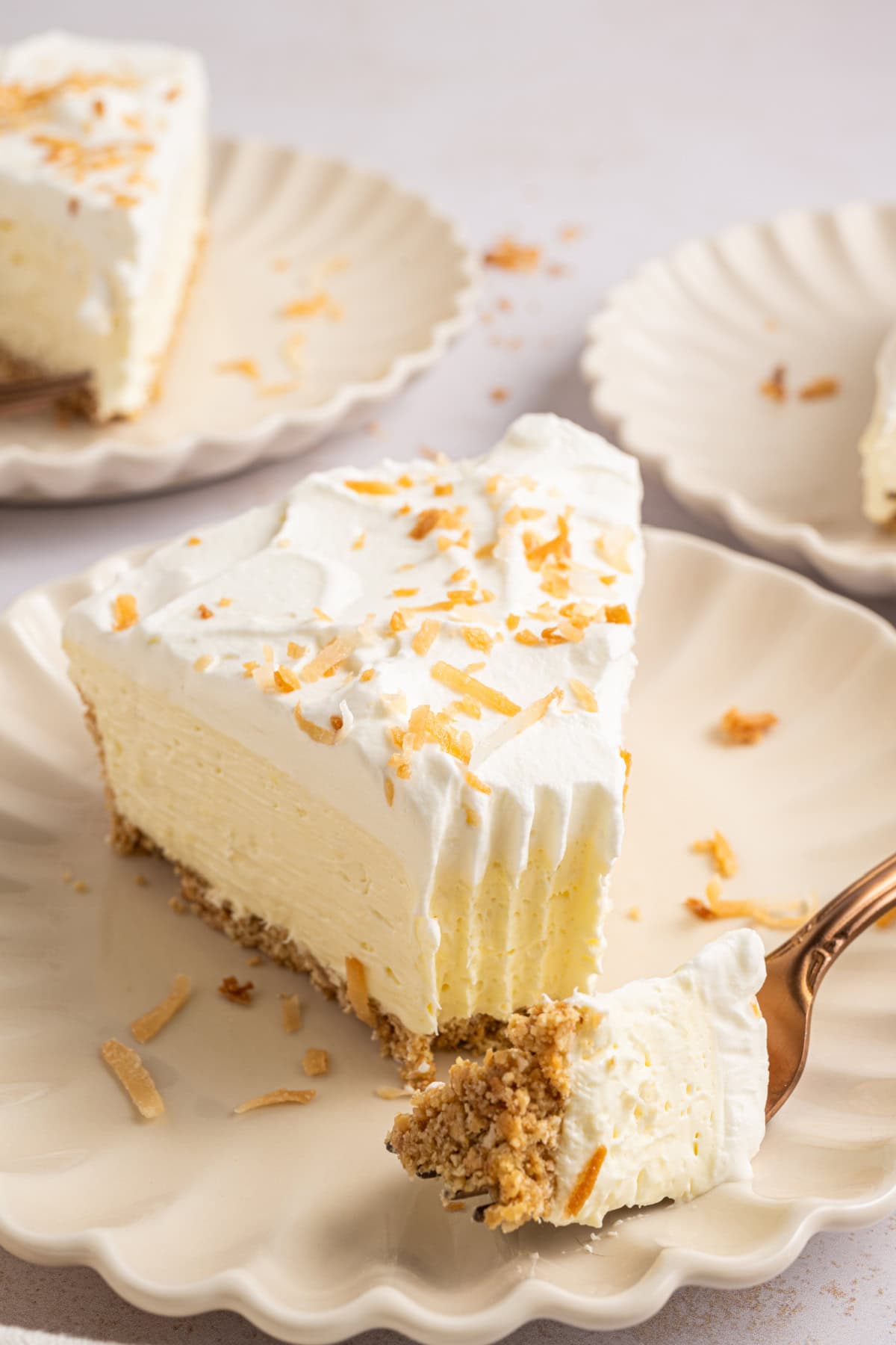 A slice of coconut cheesecake on a plate.