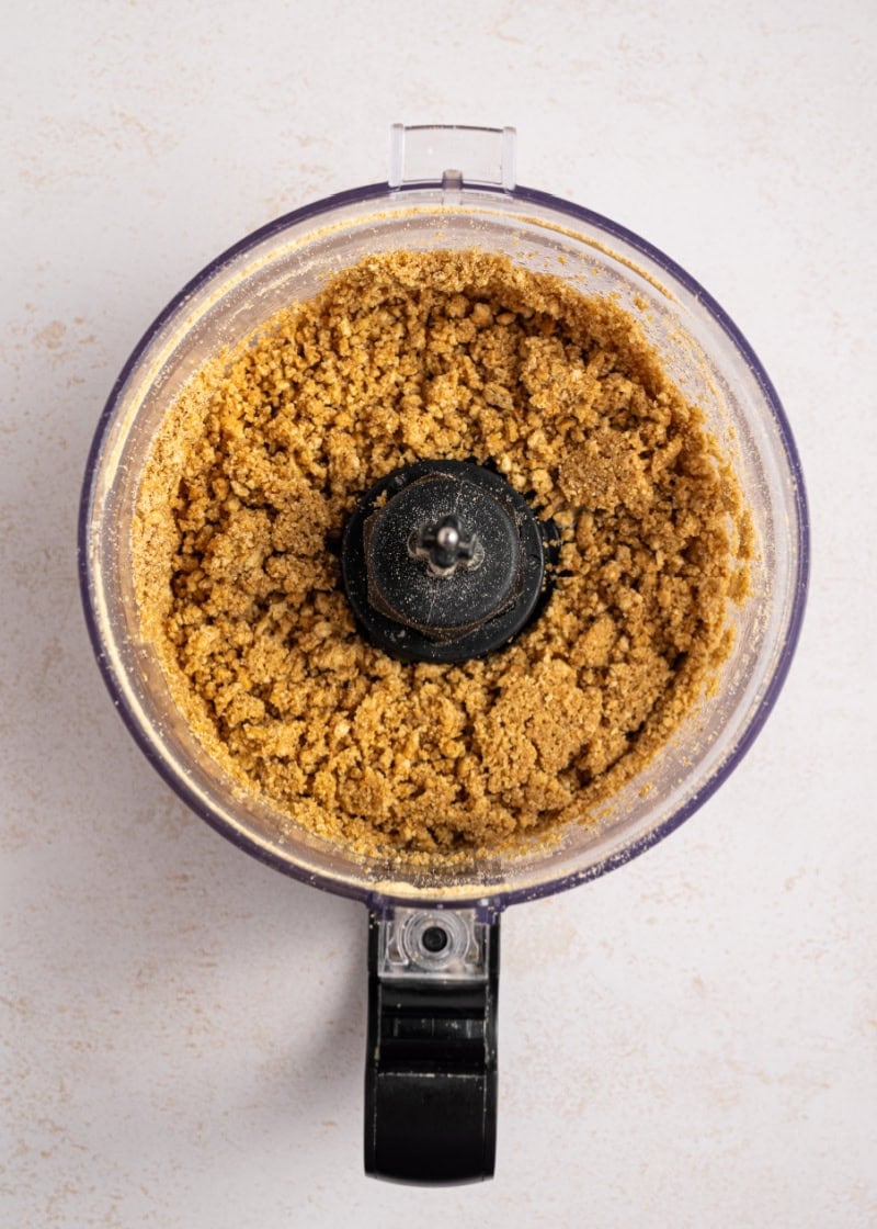 a food processor with graham cracker crumbs inside it.