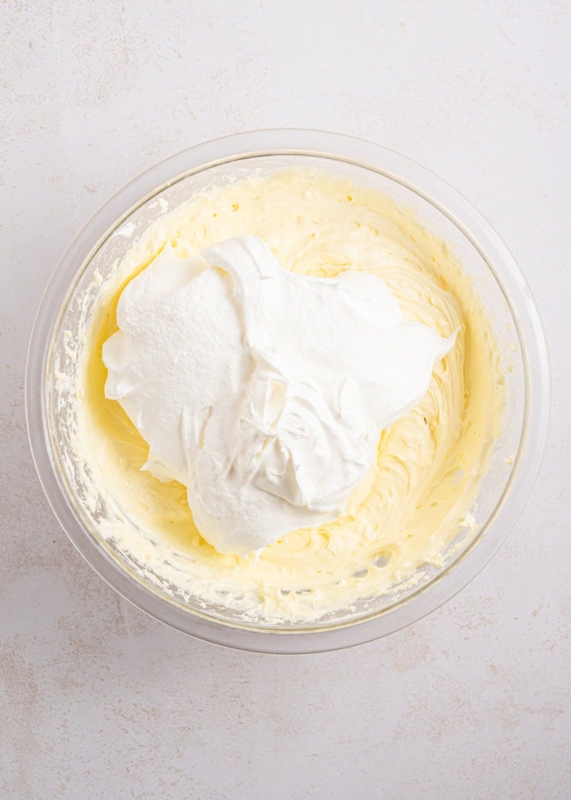 A bowl of pudding mix and whipped cream.