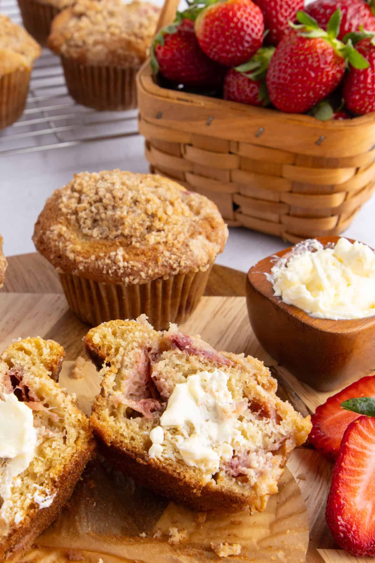 Strawberry rhubarb muffins with butter spread on top of one.