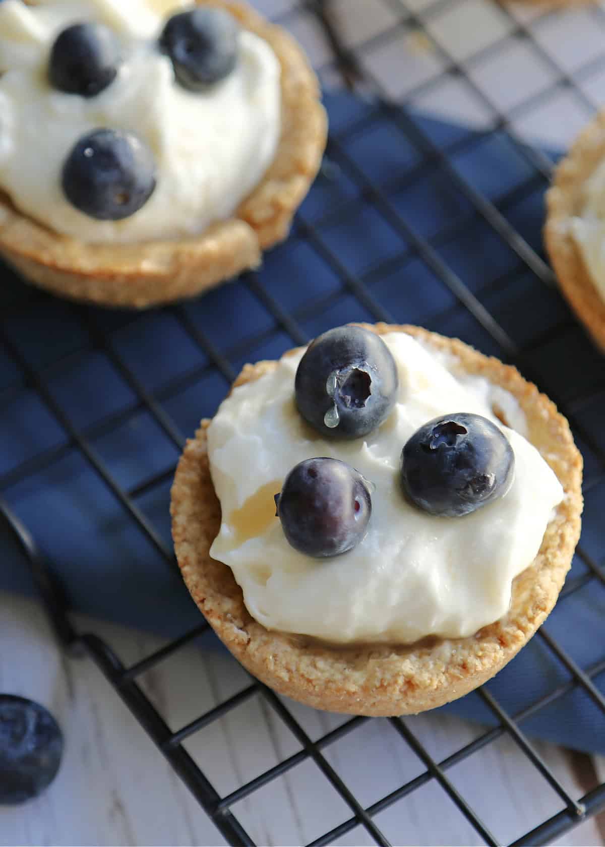Blueberry salted caramel tarts on a cooling rack.