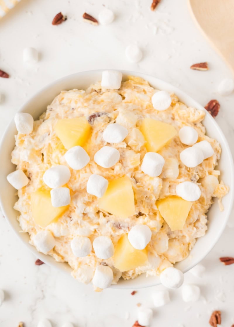 Pineapple Fluff salad in a white bowl with marshmallows and pineapple chunks on top.