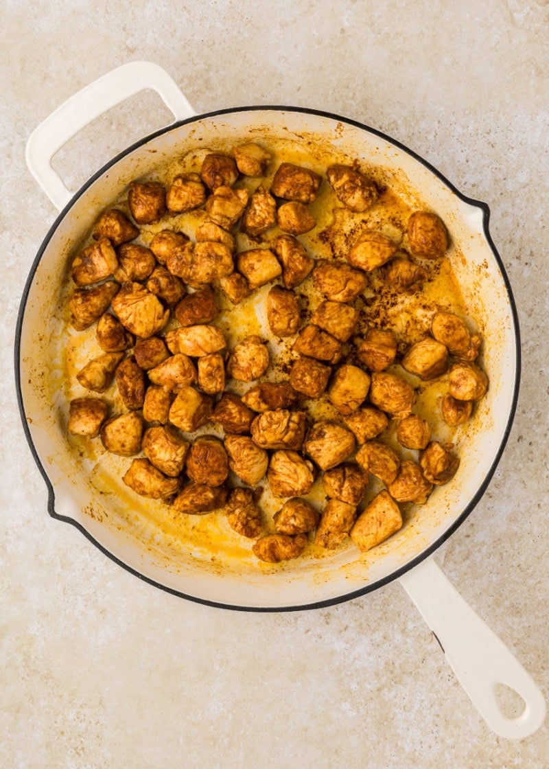 A skillet filled with cooked chicken cubes.