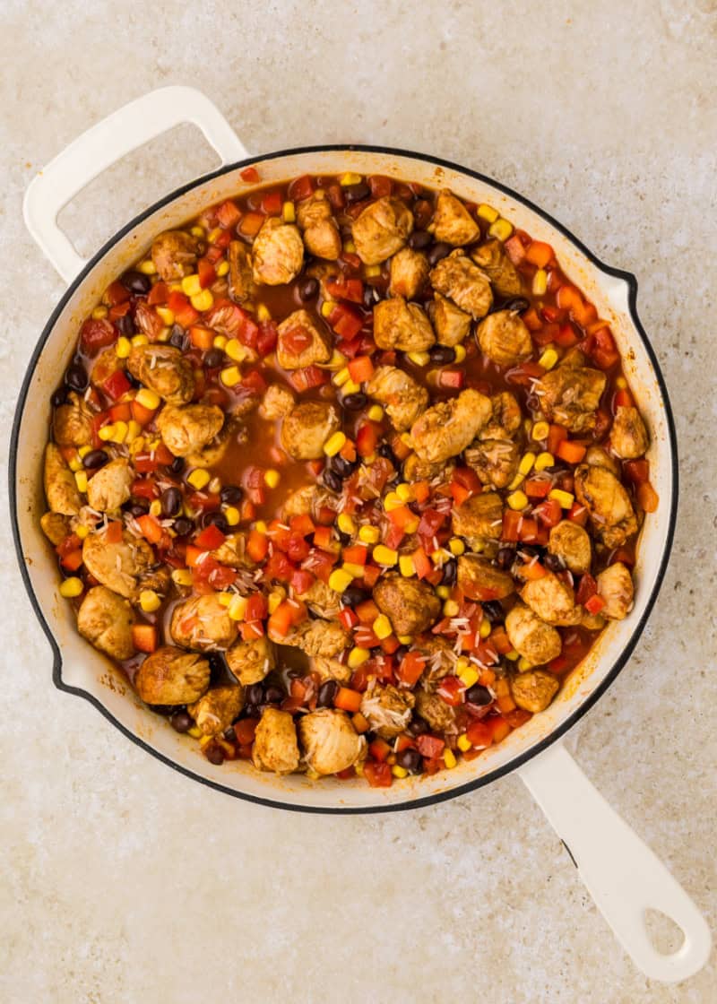 A skillet filled with chicken and vegetables.