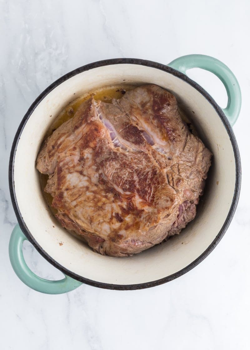 a beef roast in a dutch oven dish.