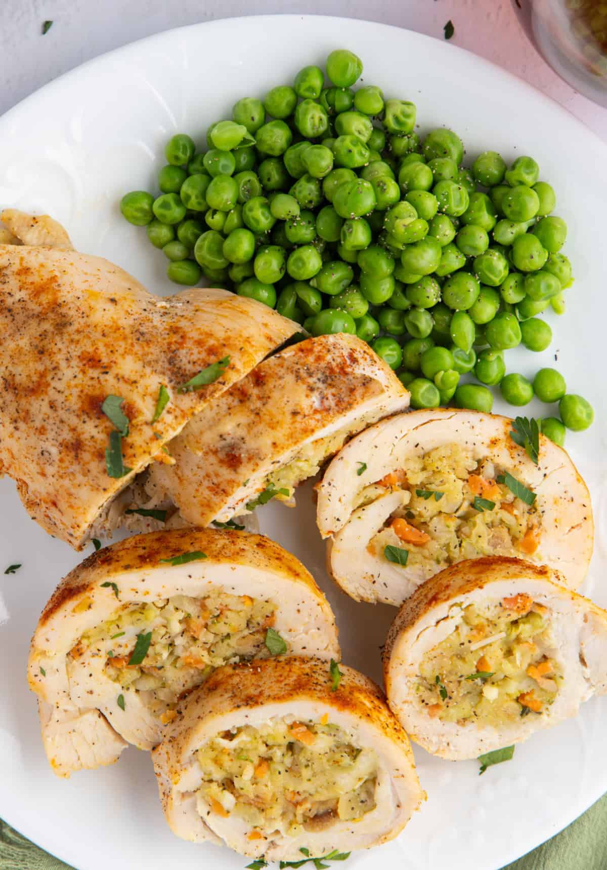 Stuffed chicken breast stuffed with stuffing and served with peas.