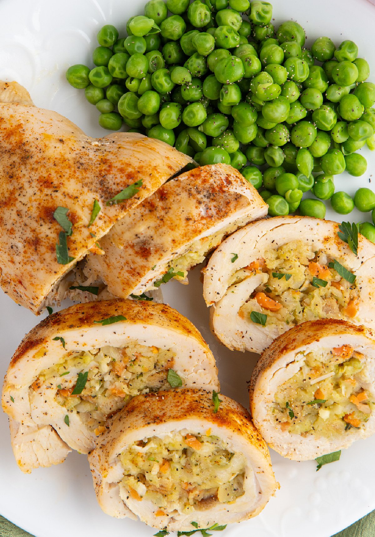 Stuffed chicken breast stuffed with stuffing and served with peas.