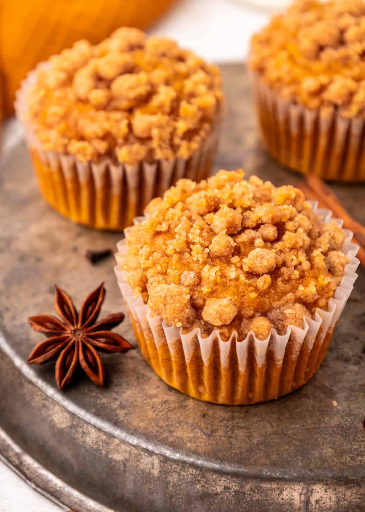 Pumpkin Streusel Muffins on a plate with cinnamon sticks and star anise.