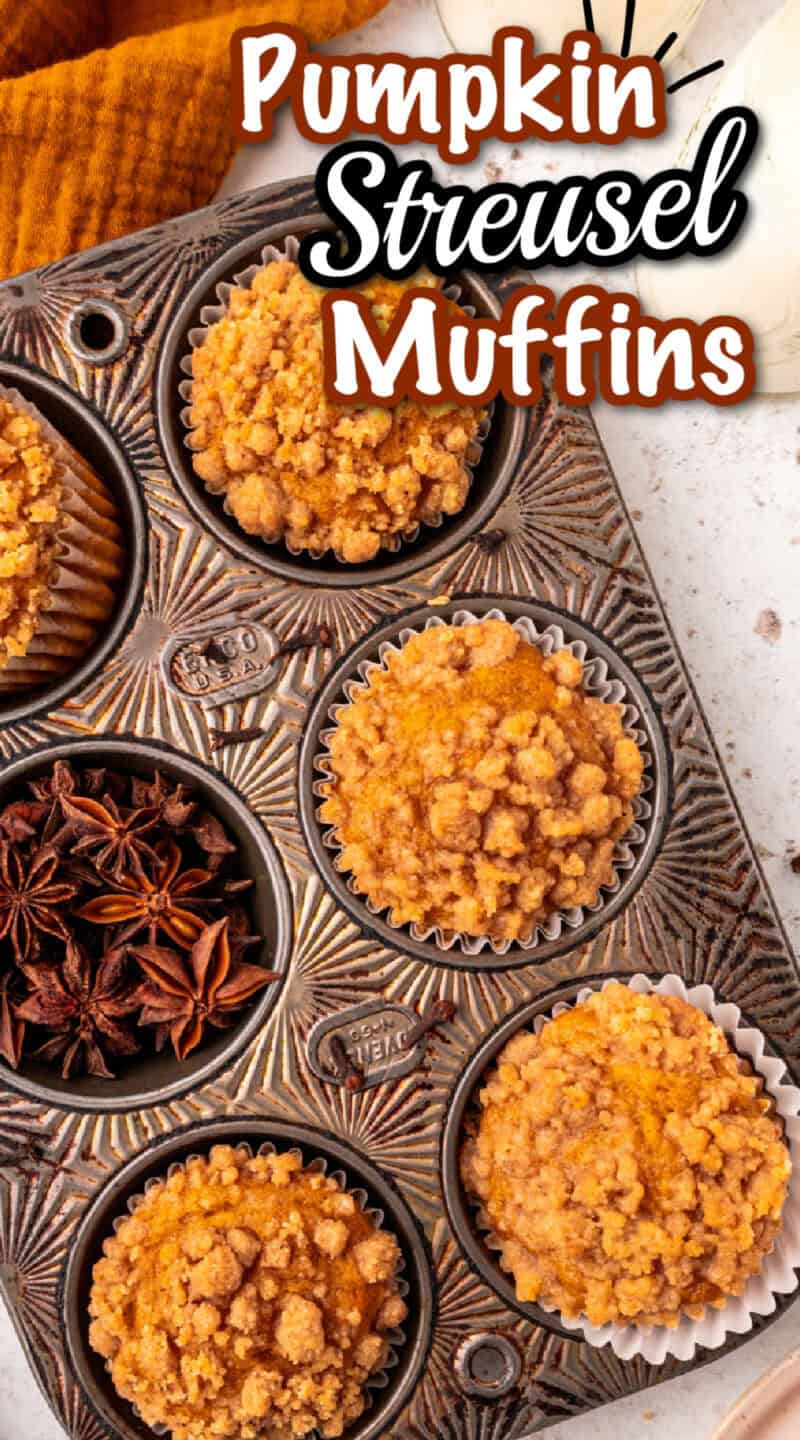 Pumpkin Streusel Muffins in a muffin tin on a table with a jug of milk.