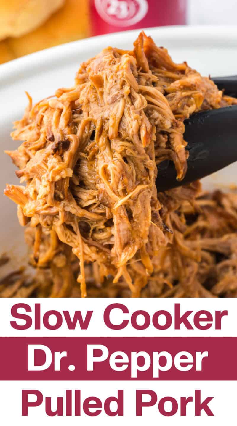 Slow cooker pulled pork being lifted out of a crockpot using tongs.