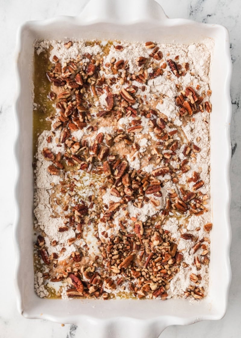 uncooked pumpkin dump cake recipe in a white baking dish.