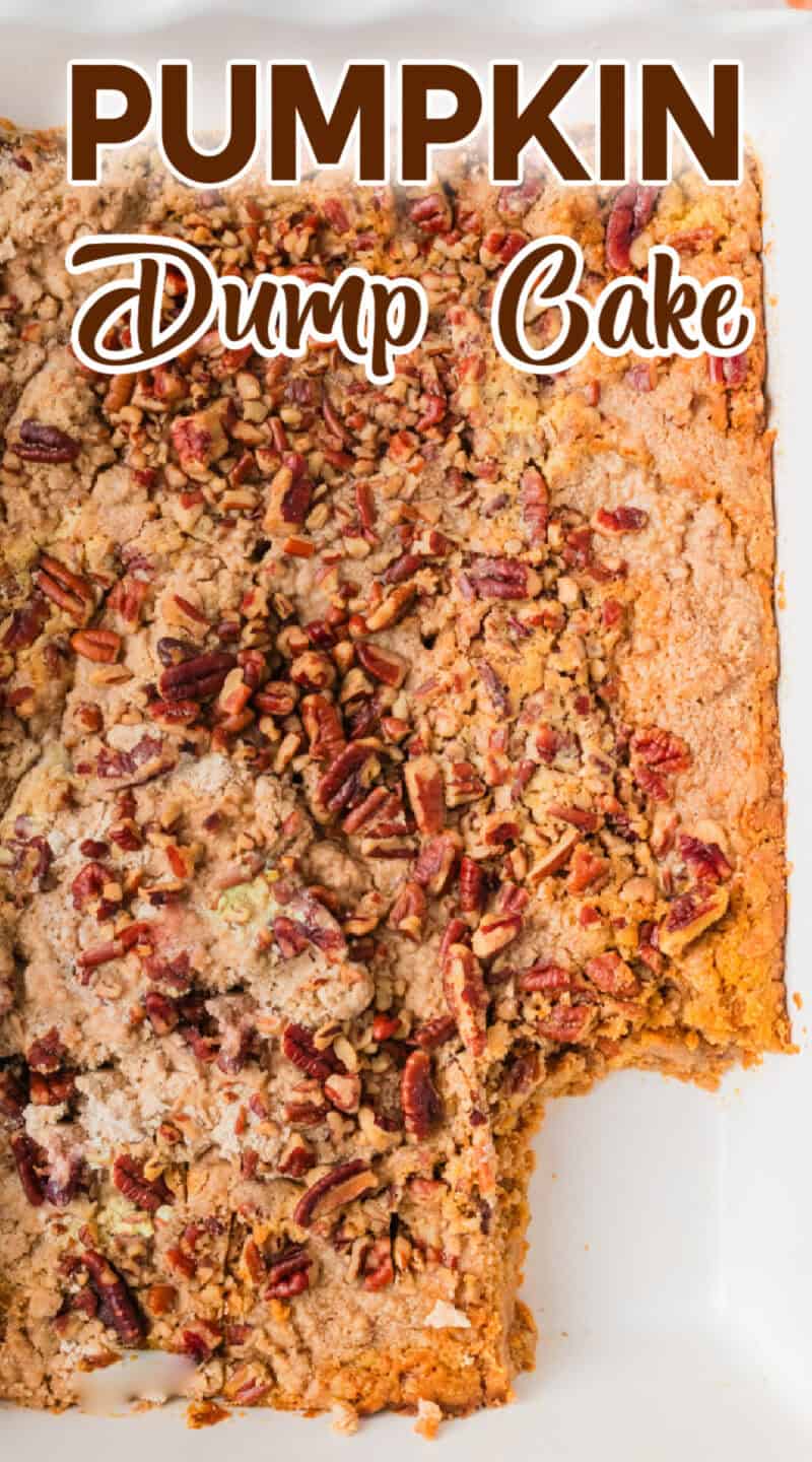 Cooked pumpkin dump cake with pecans on top, in a white baking dish, with a piece taken out.