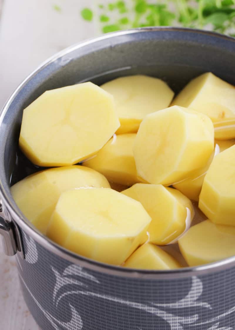 uncooked peeled and cut potatoes in a pot of water.