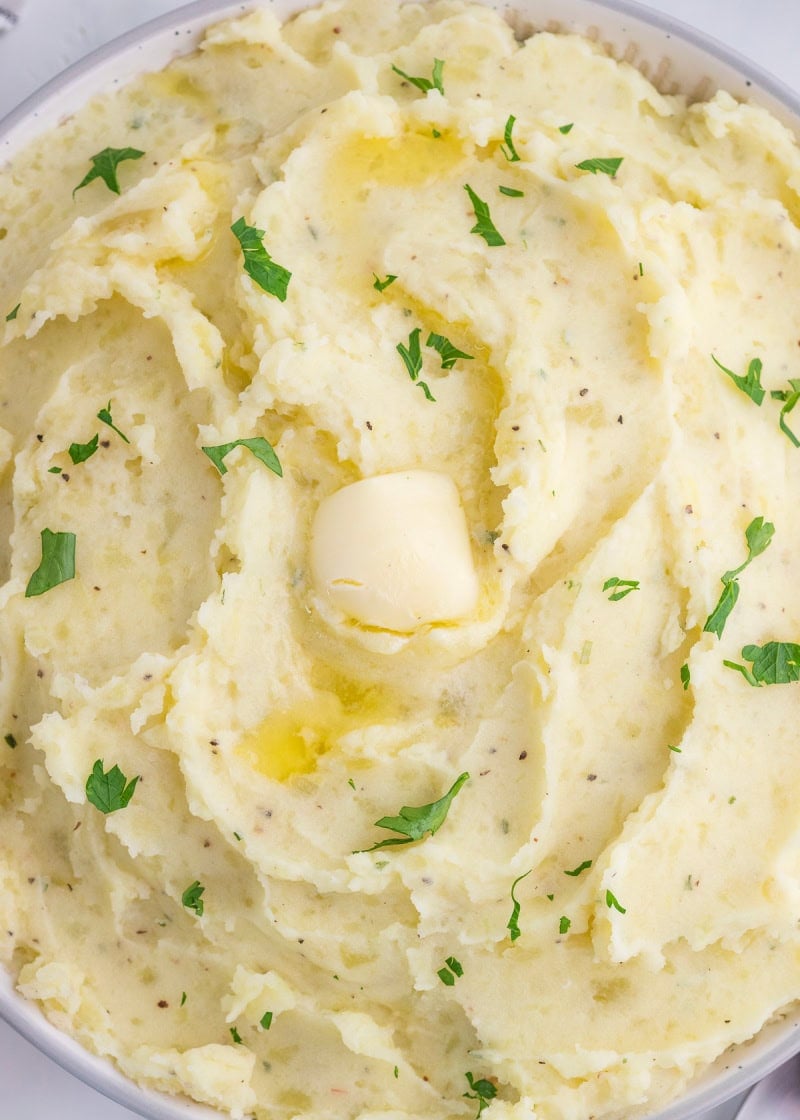 buttery mashed potatoes garnished with chopped parsley and black pepper.