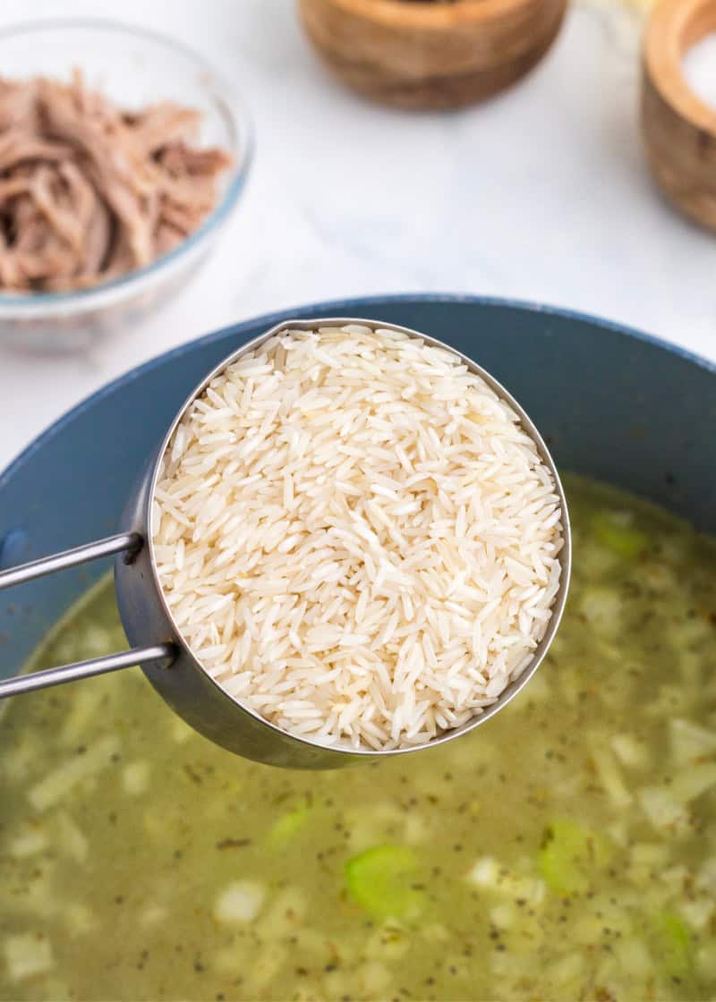 rice being poured into a soup pot.
