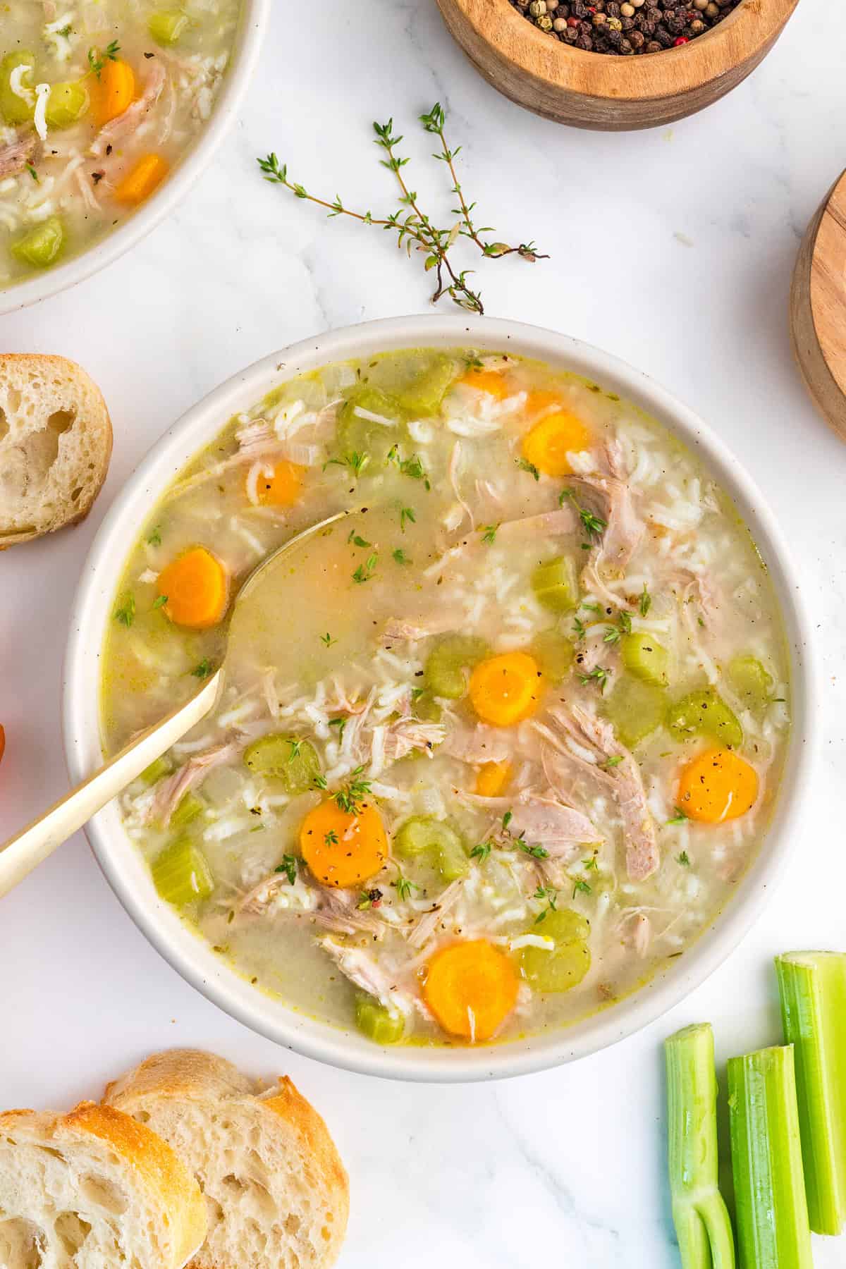 a bowl of Turkey and Rice Soup on a table with bread slices.