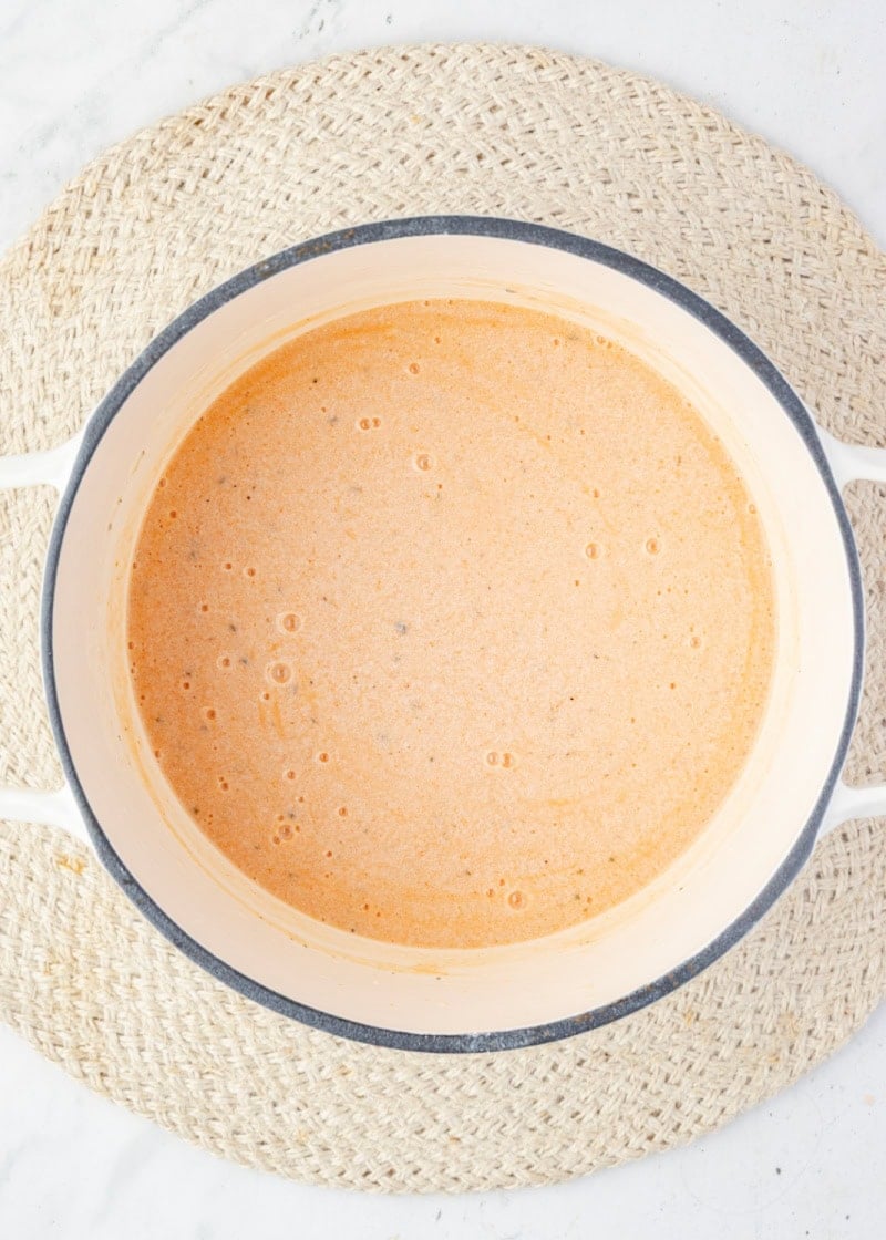 melted cheese and milk in a pot to make homemade mac and cheese.