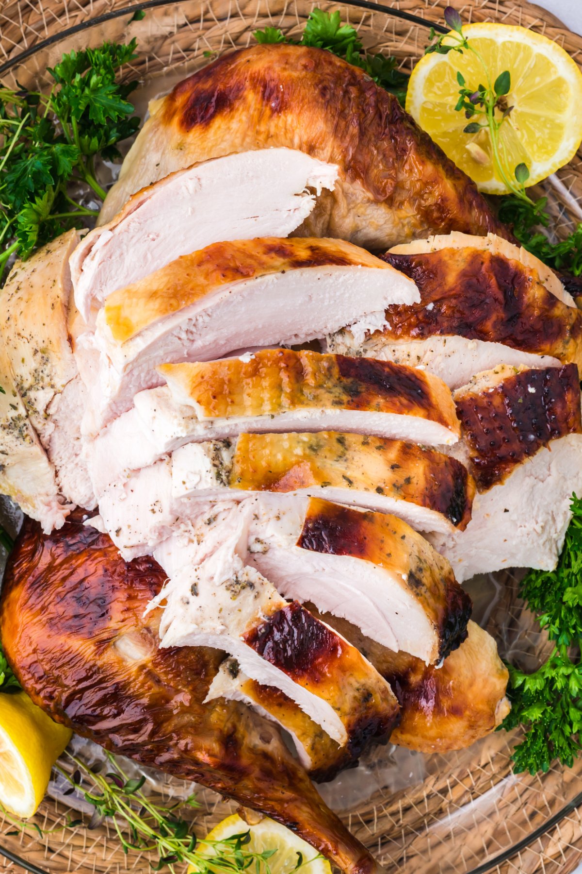 slices of honey glazed tureky surrounded by fresh green and lemon slices.