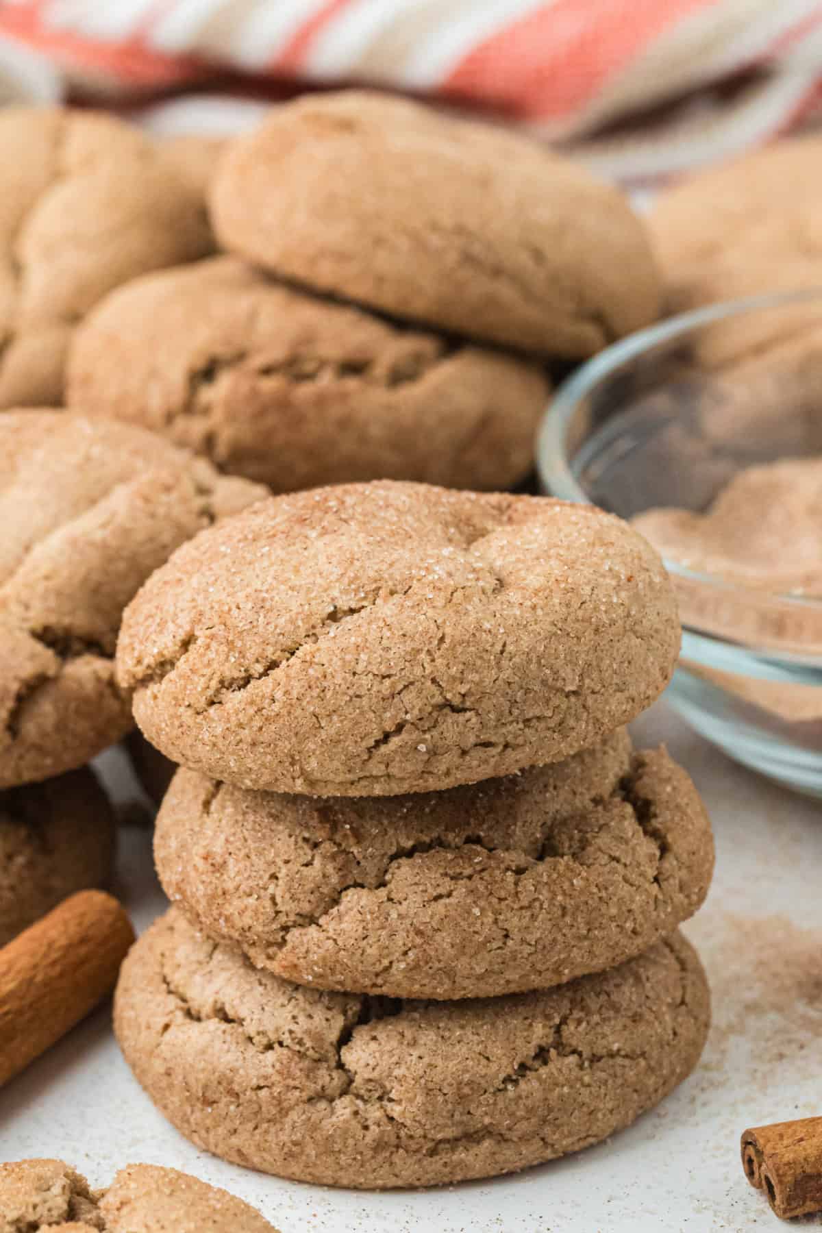 Spice Cake Mix Cookies in a pile with cinnamon sticks beside it.