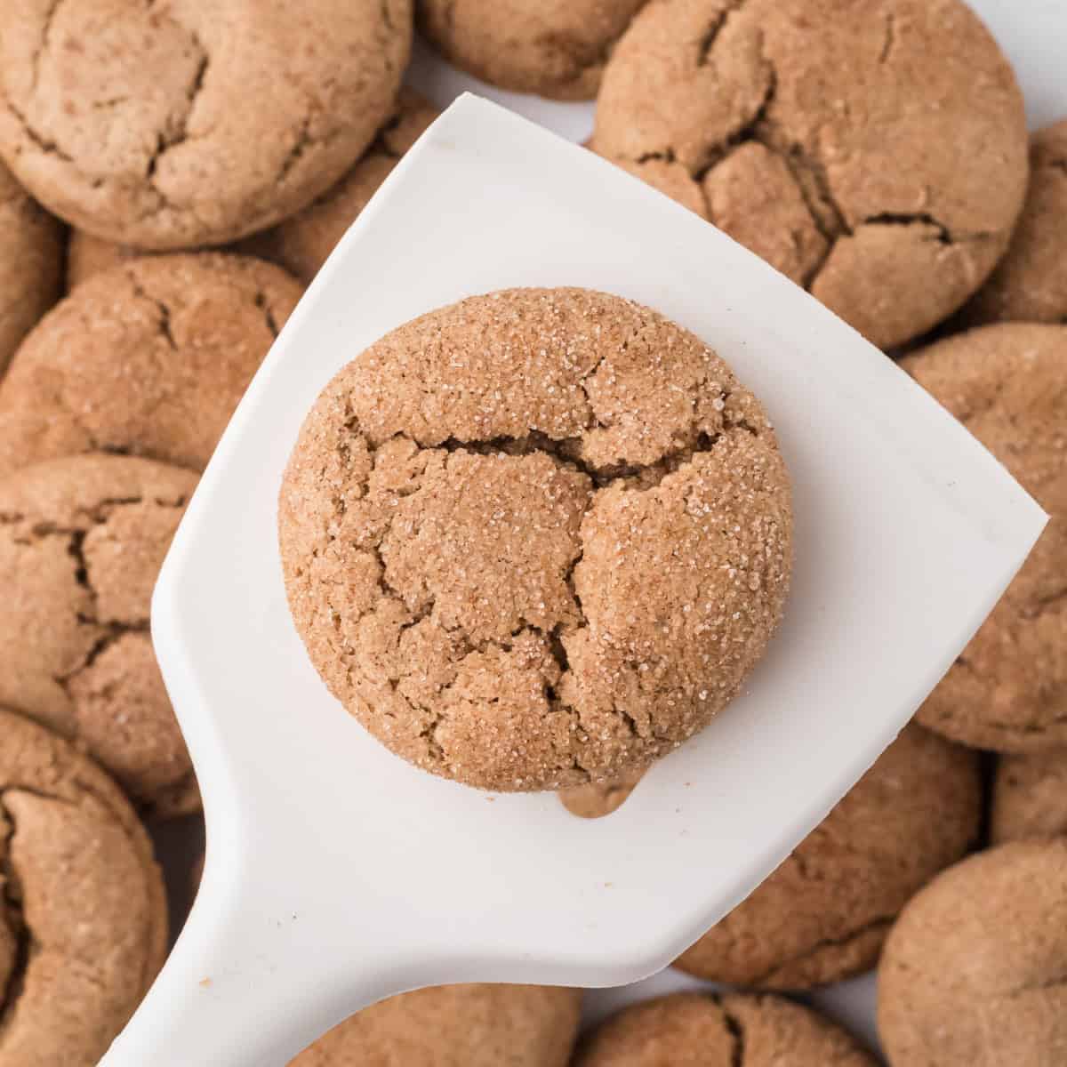 a Spice Cake Mix Cookie on a white spatula over a tray of Spice Cake Mix Cookies.