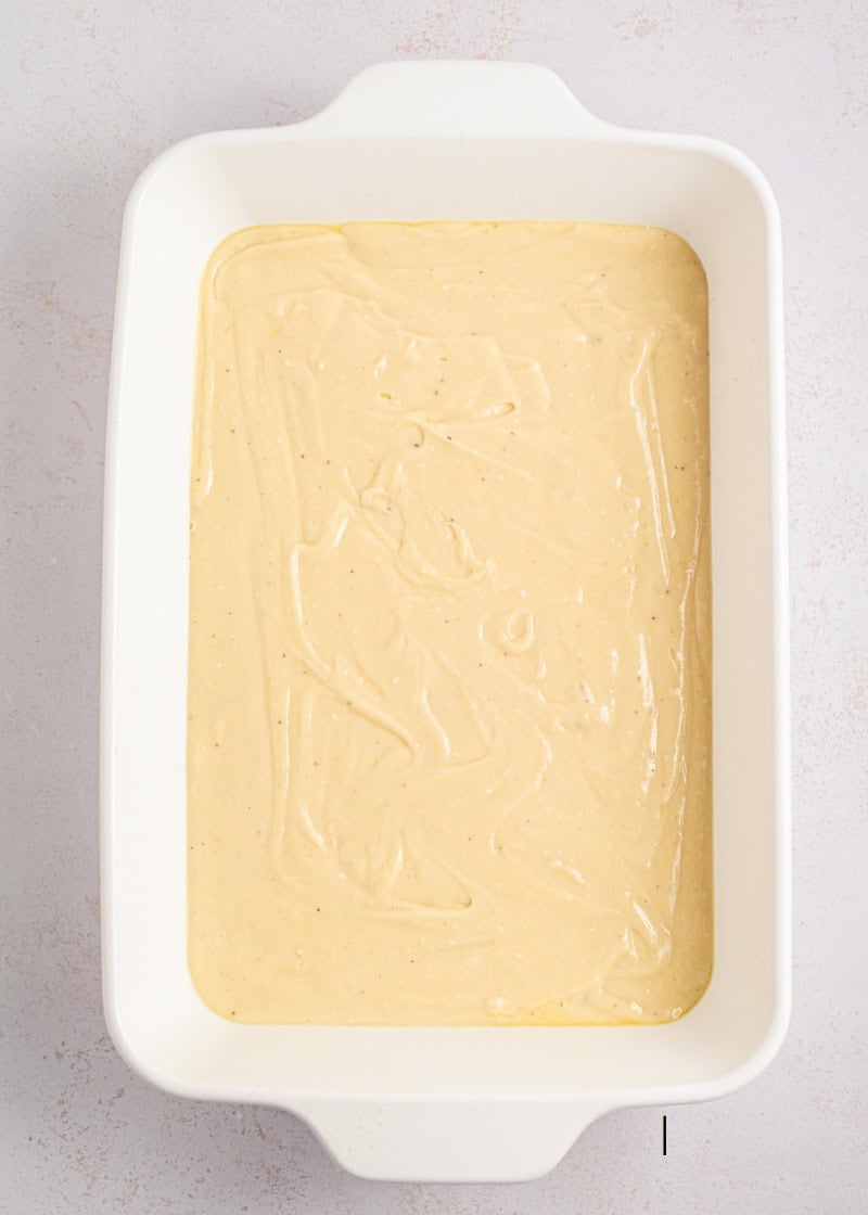 uncooked cake batter in a white baking dish.