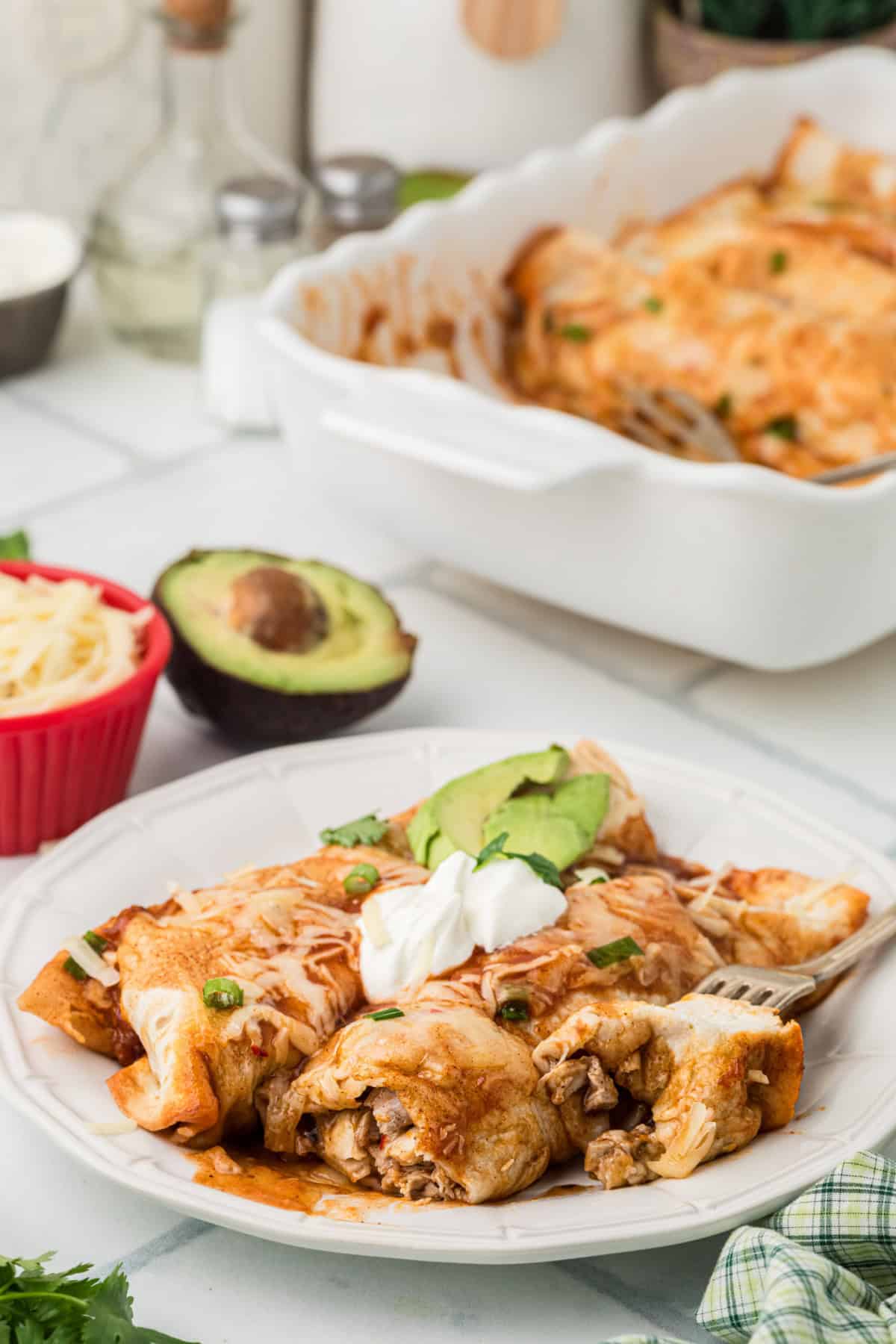 Turkey Enchiladas on a plate and in a baking dish.