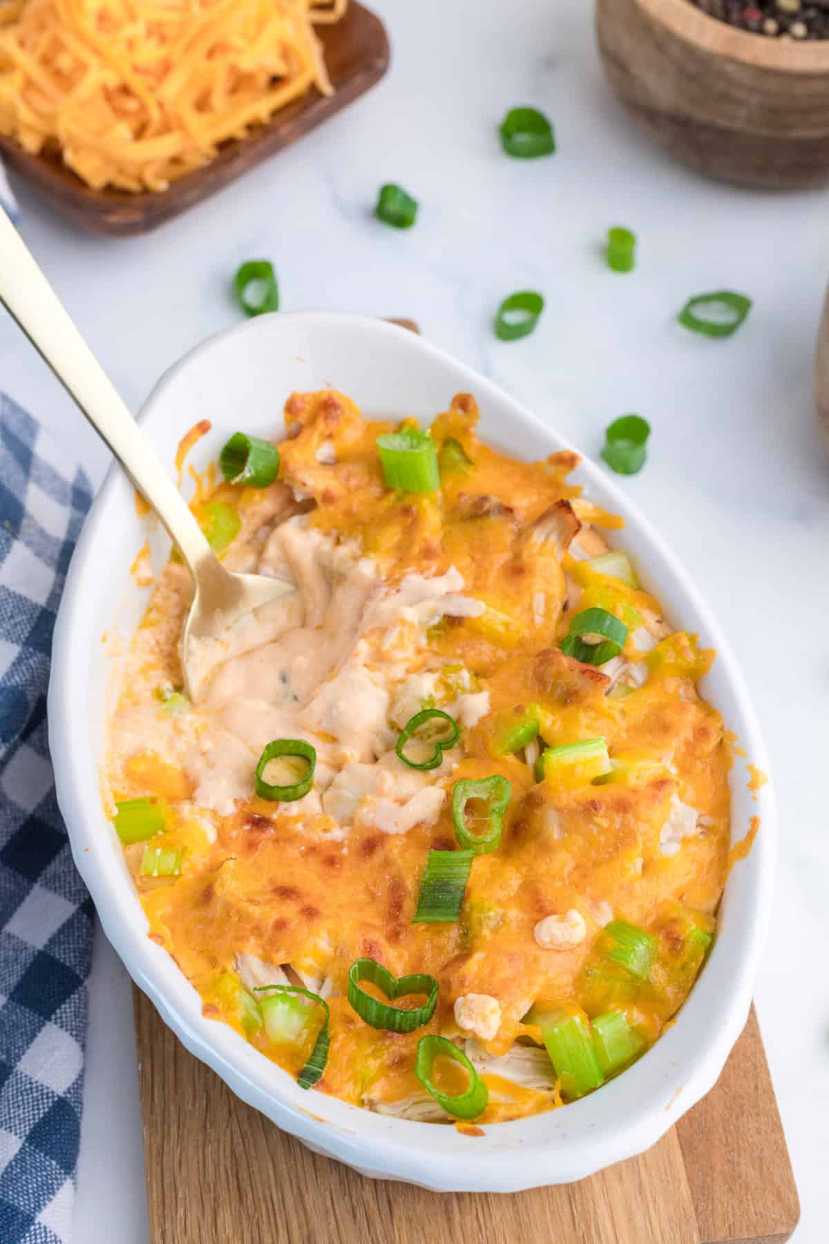cooked cottage cheese buffalo chicken dip in a white dish with a spoon in it.